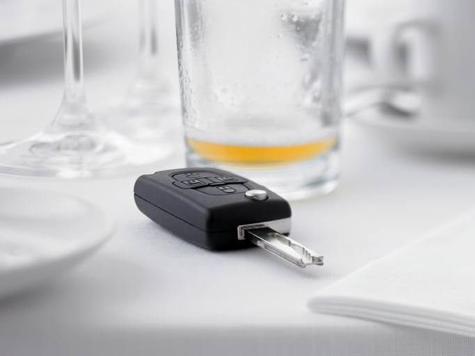 Close up of remote entry car key on restaurant table next to empty beer glass